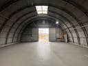 Large Empty Warehouse with high arched metal ceiling and lobby loft space